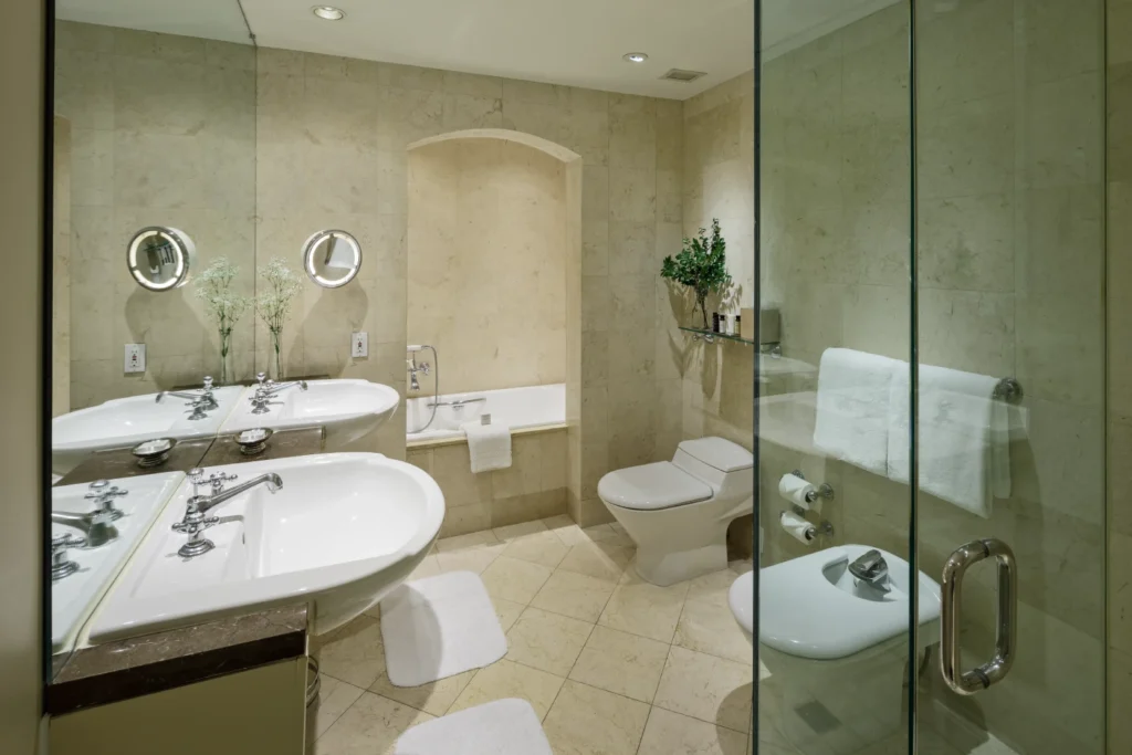 a bathroom with two sinks, a toilet and a shower