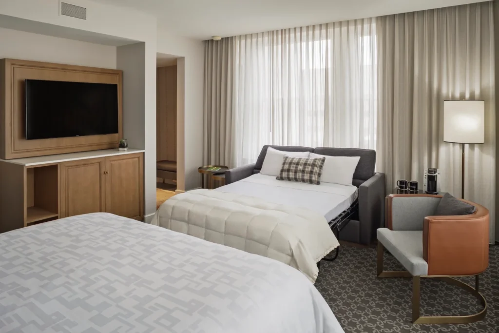 a hotel room with a bed, chair and television