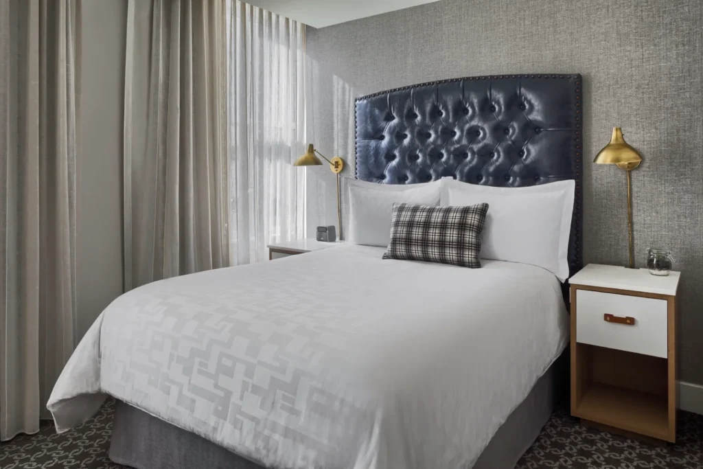 a bedroom with a white bed and a blue headboard