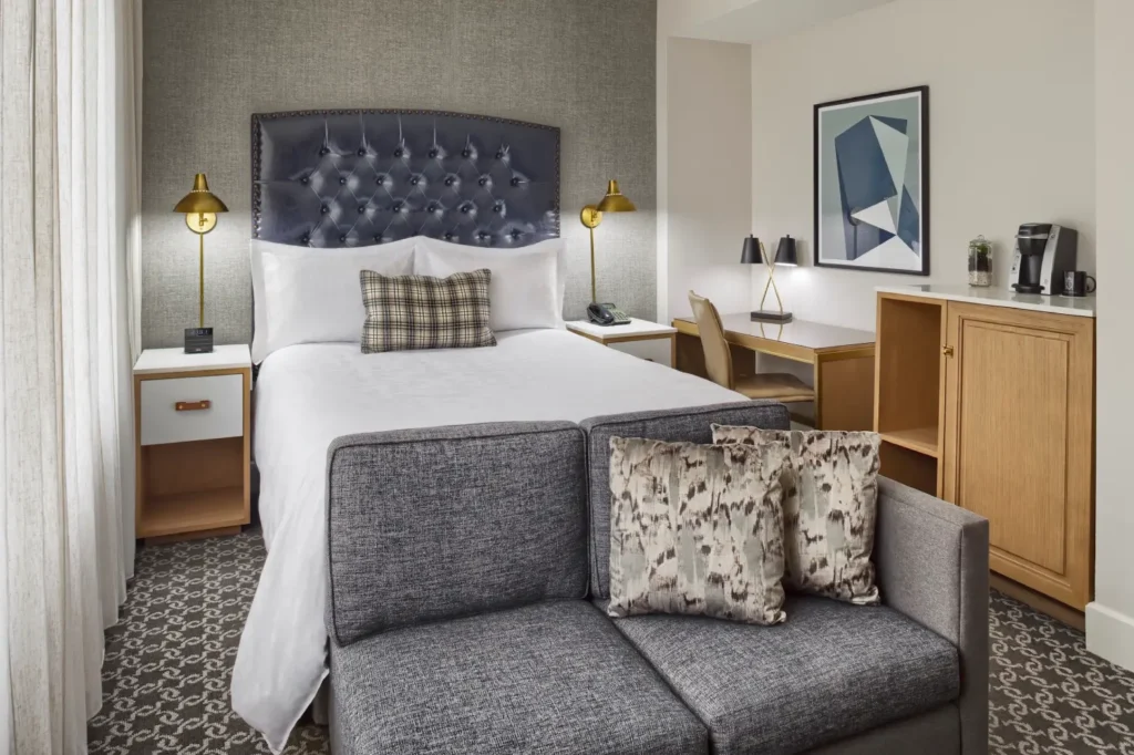 a bed sitting in a bedroom next to a window