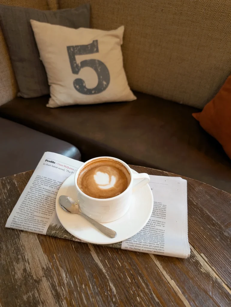 a cup of coffee sitting on top of a wooden table