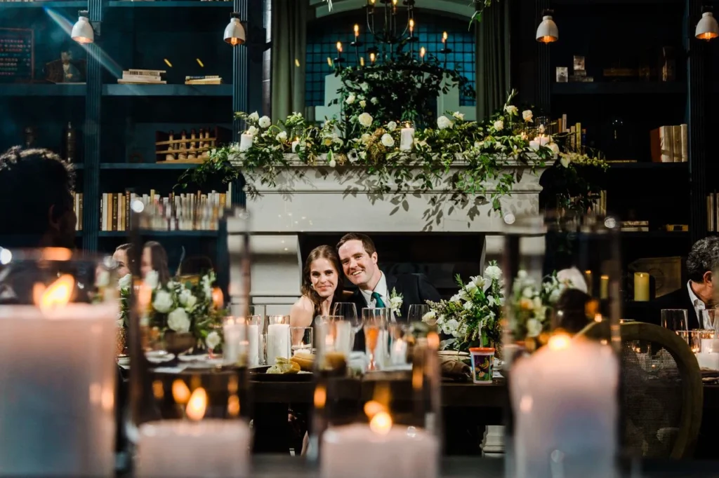 a man and a woman sitting at a table with candles