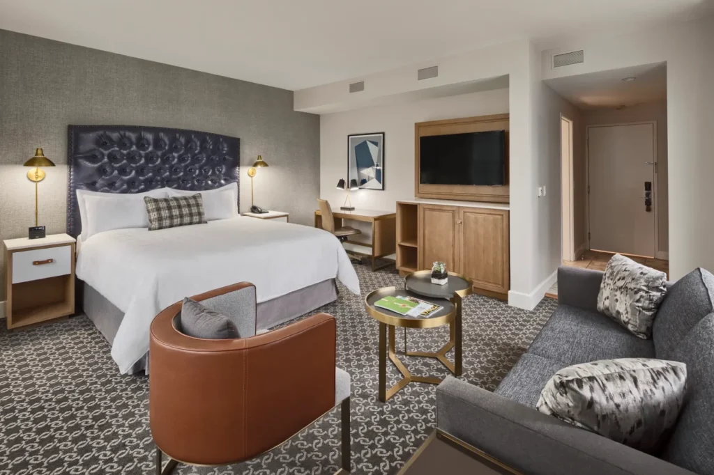 a hotel room with a bed, couch, and television