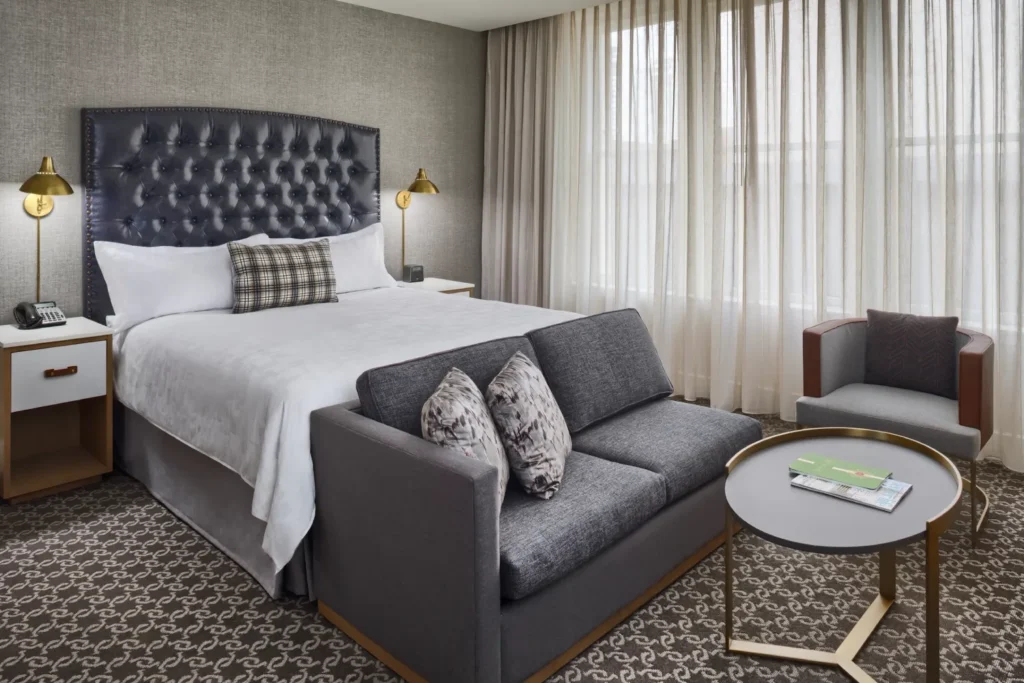 a hotel room with a bed, chair, and desk