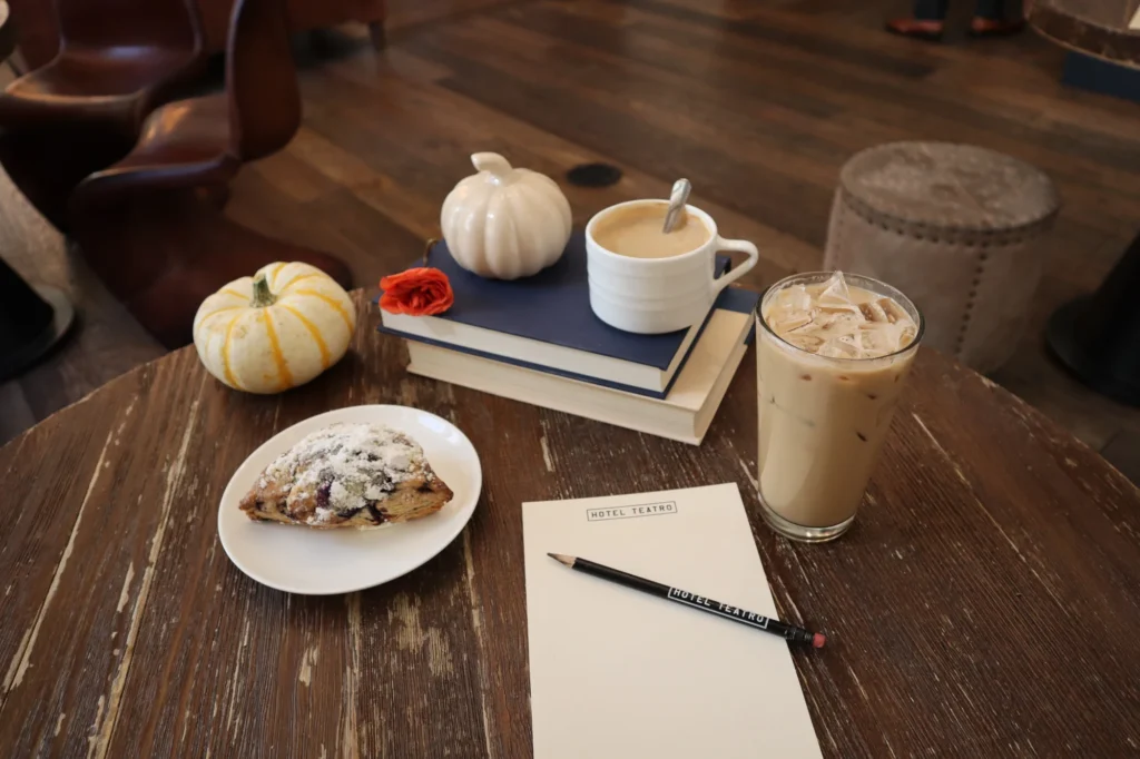 a wooden table topped with a plate of food and a cup of coffee
