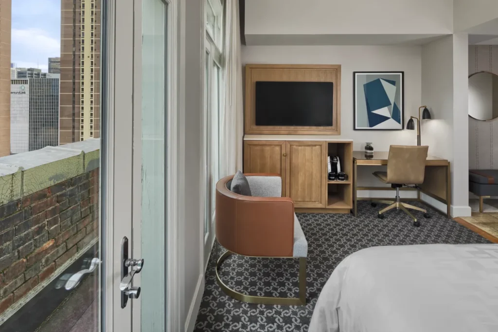 a bedroom with a bed, desk, chair and television