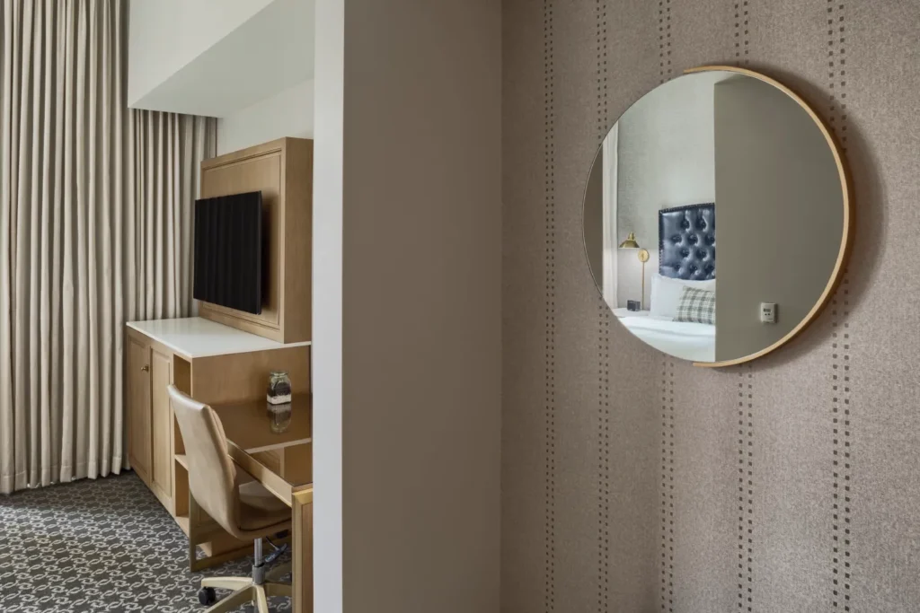 a mirror hanging on a wall next to a desk