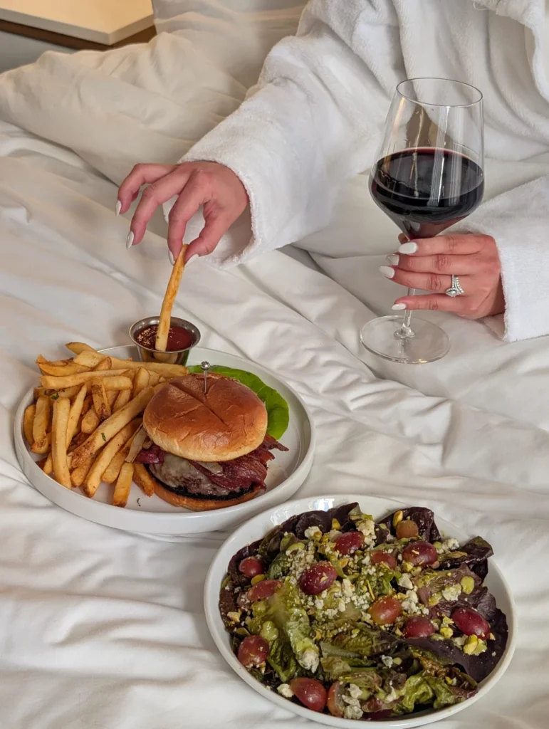 a person in a white robe and a plate of food and a glass of wine