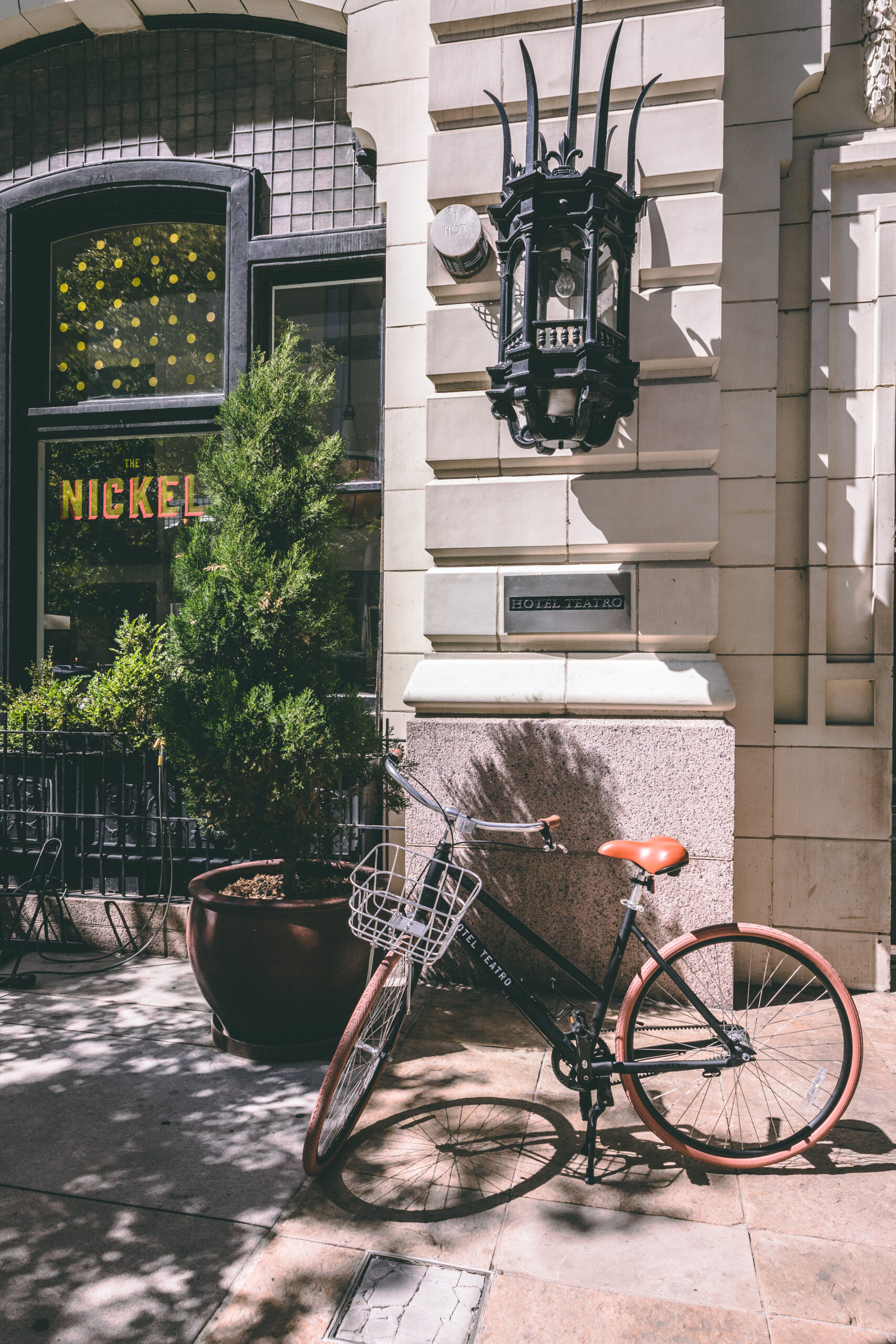 a vintage bicycle that says "Hotel Teatro" in front of the historic Hotel Teatro and The Nickel restaurant in Downtown Denver
