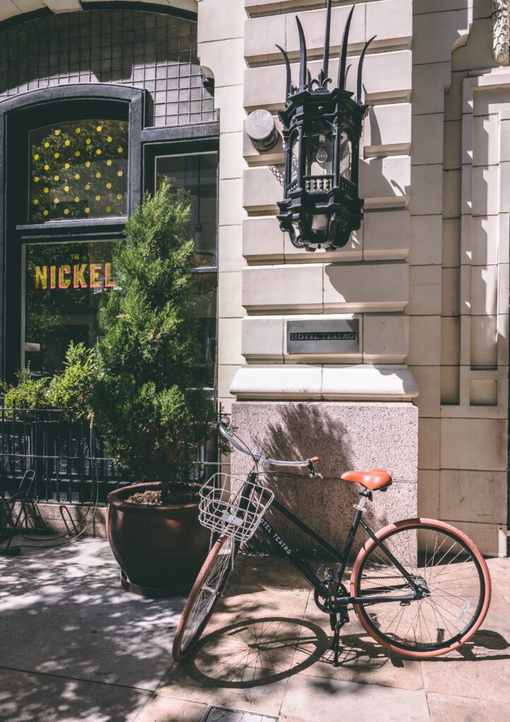 A bicycle parked outside a building with a large window and a sign that reads "Nickel" in yellow letters.