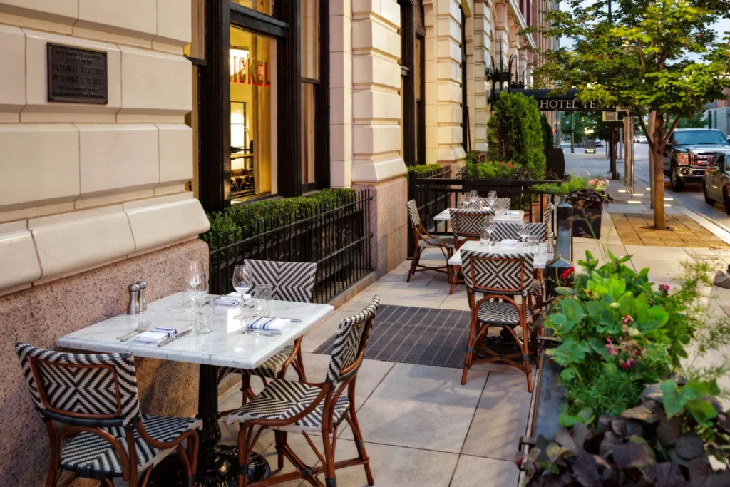 a sidewalk with tables and chairs on it