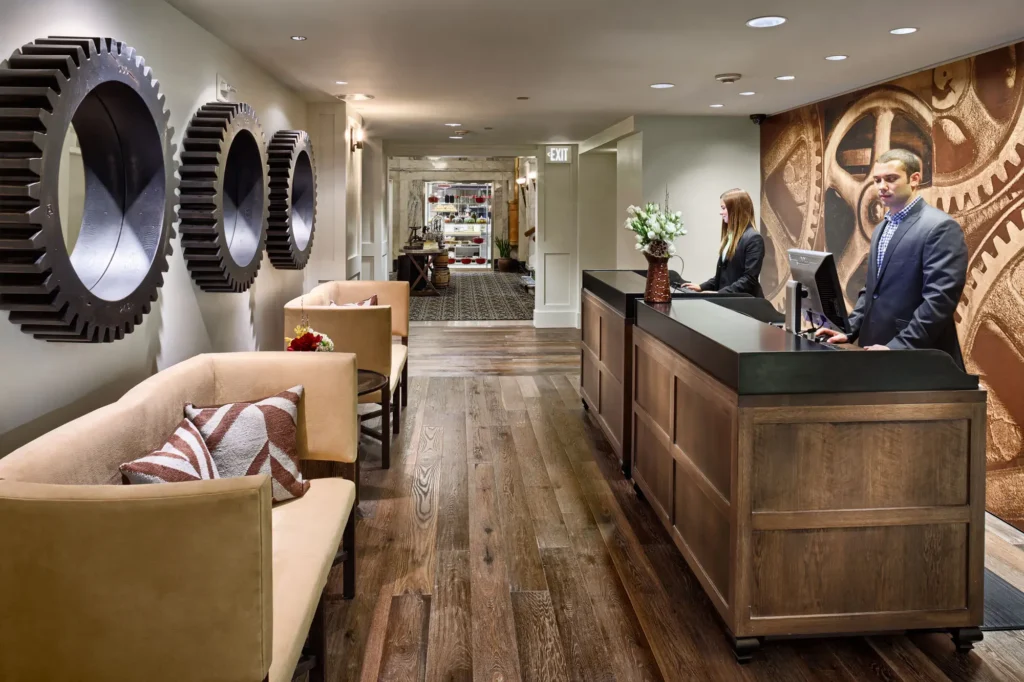 a man standing at the front desk of a hotel
