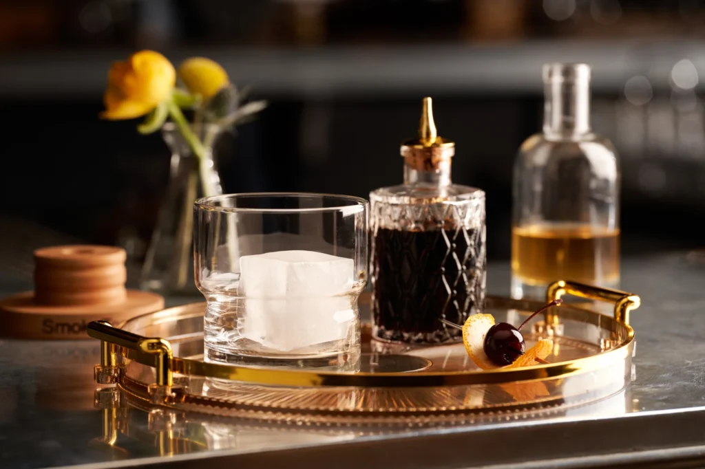 a tray with a bottle of liquor and two glasses on it