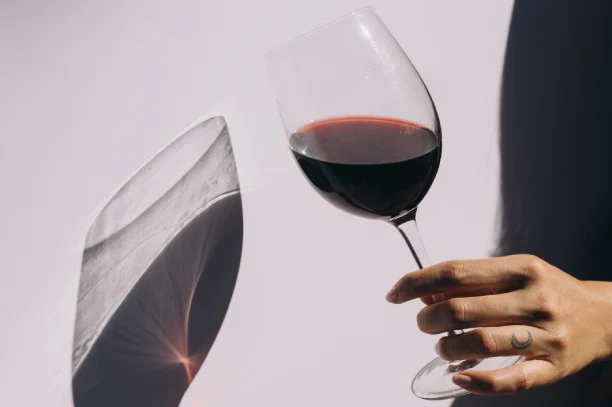 Red Wine and Striking Shadows woman holding a glass of red wine